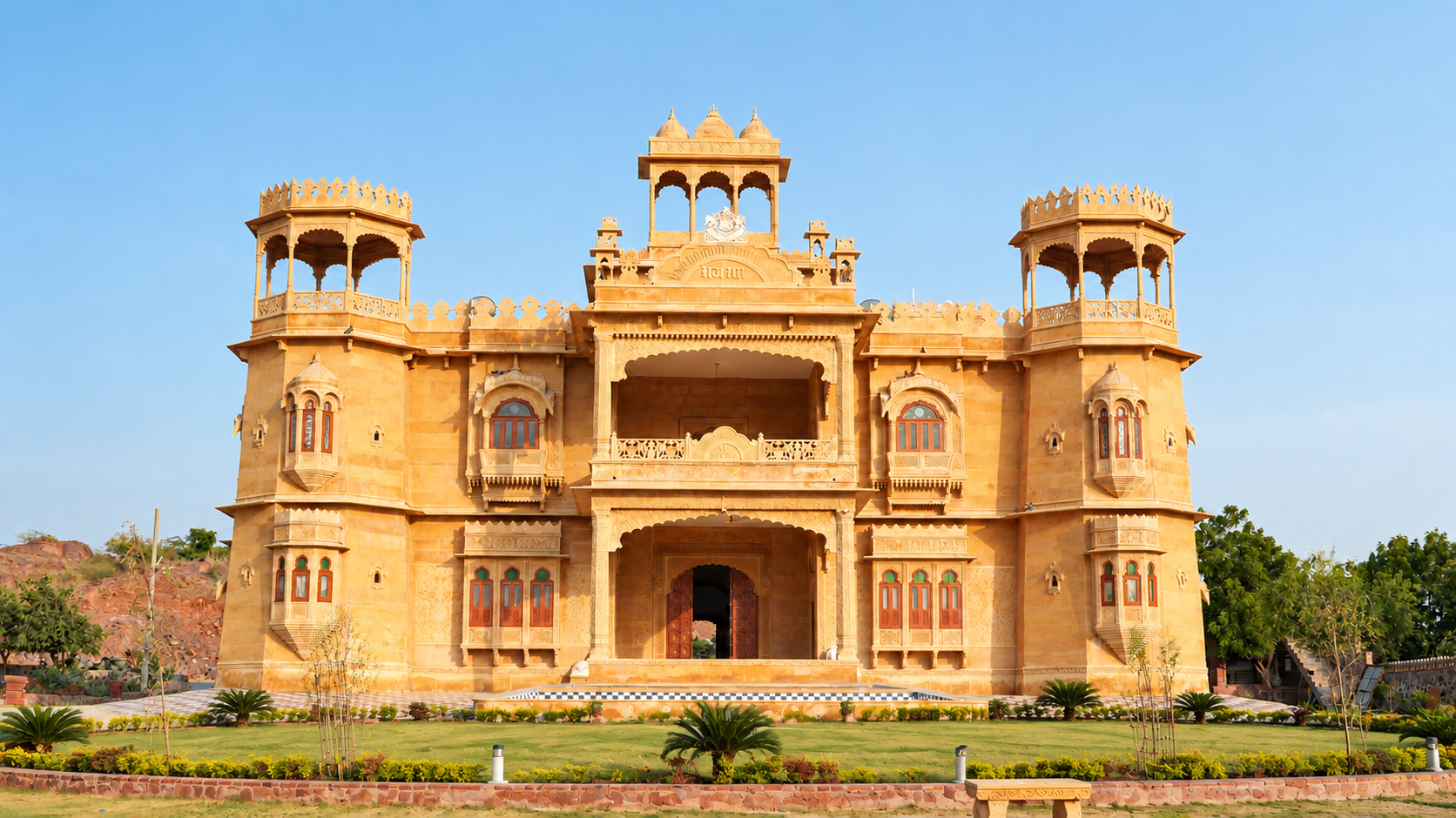 Symmetrical sandstone façade of Maalani Raj Heritage viewed across its gardens